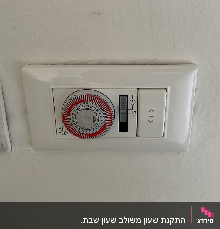 שעון טיימר חשמלי ולחצן על קיר לבן